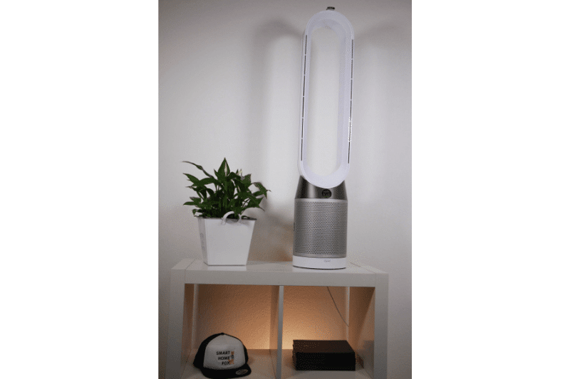 Очиститель воздуха и башенный вентилятор Dyson Pure Cool TP05 стоит рядом с растением на белой полке.